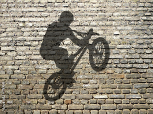 Fototapeta na wymiar Rowerzysta BMX na ceglanej ścianie