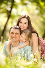 Happy mother, father and daughter in the park