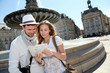 © goodluz - Couple standing by a fountain in Bordeaux with map