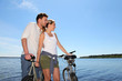 © goodluz - Couple standing on a bridge with bicycles