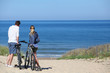 © goodluz - Couple with bicycles looking at the ocean