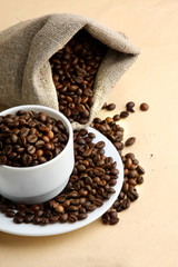 A sack of coffee beans and a cup, closeup