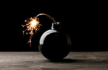 Cartoon Style Bomb On Wooden Table On Black Background