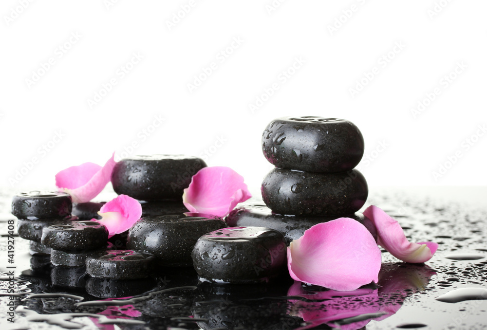 Spa stones with drops and rose petals on white background