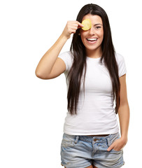 Wall Mural - portrait of young woman holding a potato chip in front of her ey