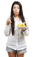 Wall Mural - young woman eating potatoe chips against a white background