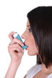 Woman using her inhaler