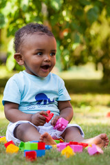 Wall Mural - Little african american baby boy playing in the grass