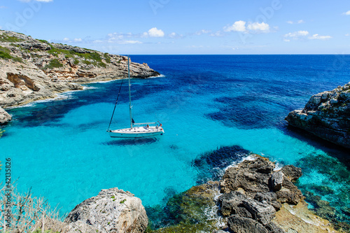 Naklejka na szybę Sailing boat at anchor. Paradise wild bay. Cala Marmolis.