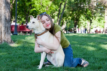 Attractive young girl playing with dog. Outdoor