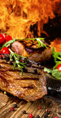 Wall Mural - Grilled beef steaks with flames on background