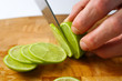 © Moving Moment - Cutting limes on a wooden chopping board