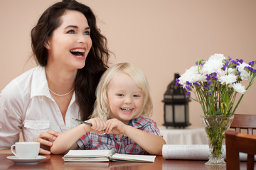 Happy mother and son at table