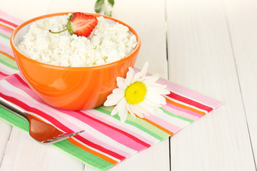 cottage cheese with strawberry in orange bowl, fork and flower