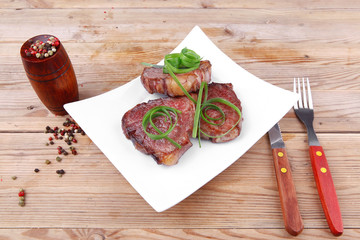 Wall Mural - steaks strips on white plate with pepper