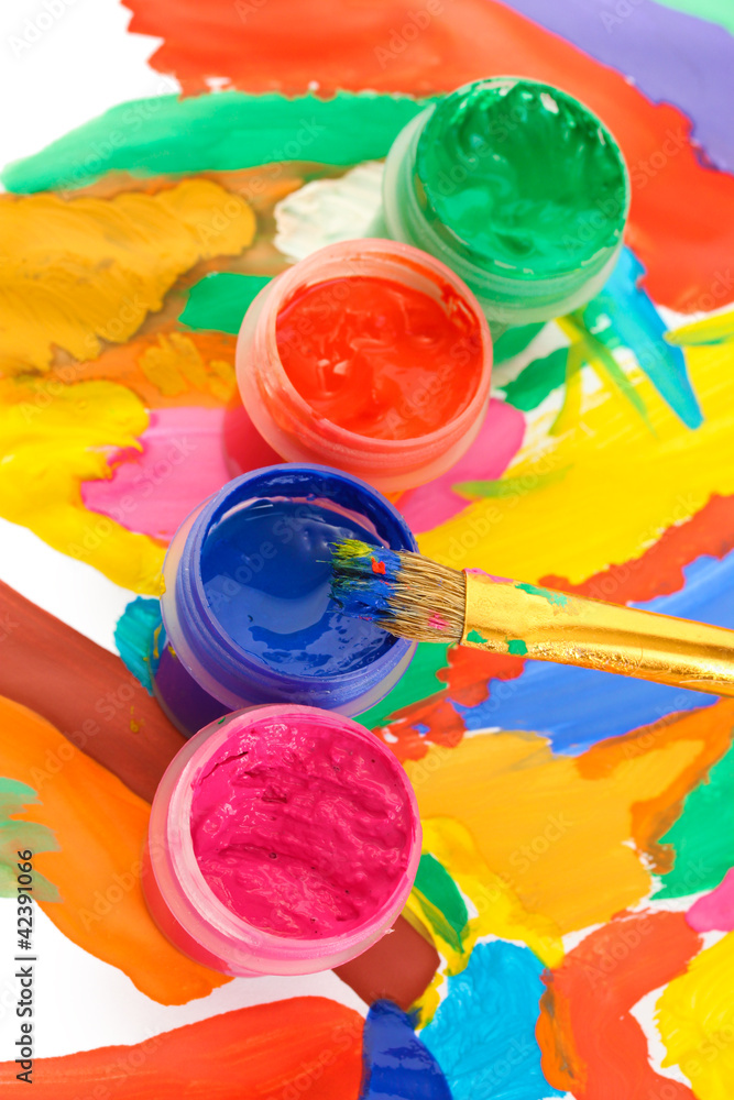 Jars with colorful gouache on a bright picture close-up