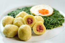 Stuffed potato dumplings with smoked meat and spinach
