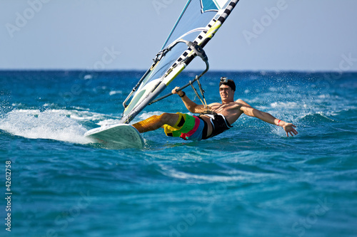 Fotoboard na płycie Młody człowiek surfing wiatr w rozpryski wody
