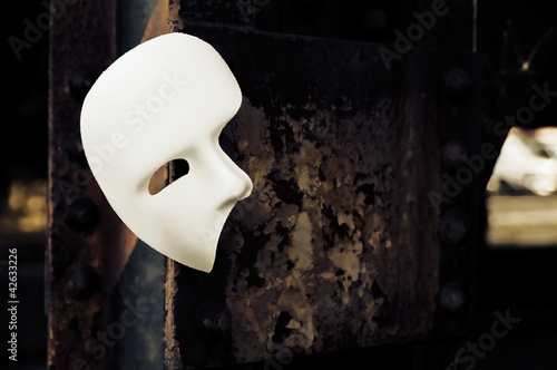 Fotografia Masquerade - Phantom of the Opera Mask on Rusty Bridge Column