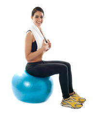 Female fitness trainer sitting on ball