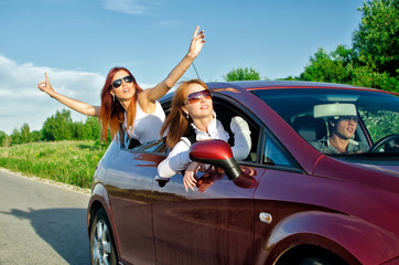 Two pretty happy girls in the car. Concept of carefree roadtrip