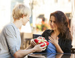 © Masson - The young man gives a gift to a young girl in the cafe
