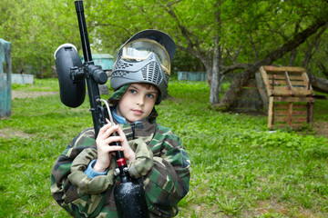 Wall Mural - Boy in camouflage suit stands against the paintball area