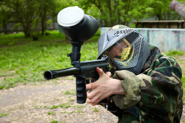 Wall Mural - Paintball player in camouflage uniform and protective mask