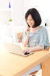 © taka - a young asian woman using laptop computer