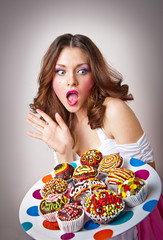 Wall Mural - young surprised woman eating cakes isolated on white