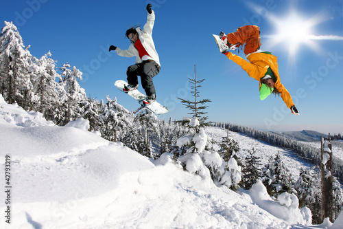 Board z aluminiowym obramowaniem Snowboardziści skaczący przeciw błękitne niebo