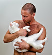 © M-Production - Muscular man holding white cat. On grey background.