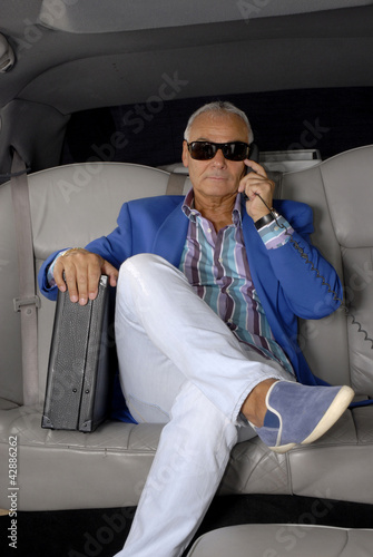 Fotografie, Obraz Hombre de negocios al teléfono en un auto.