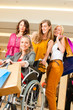 © Kzenon - Four female friends shopping in a mall with wheelchair