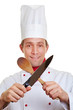 Koch kreuzt Löffel und Messer