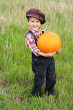 Smiling Boy Standing With Pumpkin