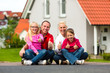 canvas print picture - Familie sitzt vor ihrem Haus