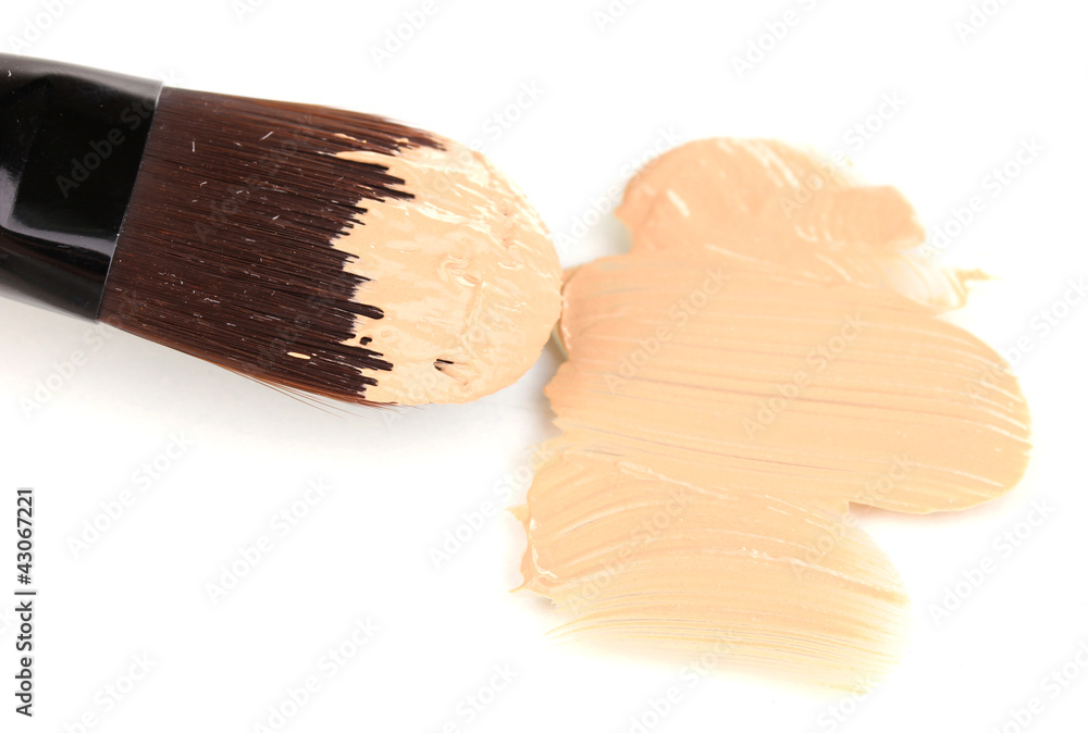 Cosmetic liquid foundation and brush isolated on white