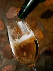 Wall Mural - Beer pouring in a glass on stone wall