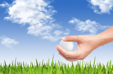 Wall Mural - Close-up of hand holding golf ball with green grass for web desi