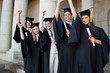 © WavebreakmediaMicro - Five happy graduates posing the arm raised