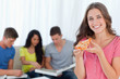 © WavebreakmediaMicro - A smiling girl with a slice of pizza in front of her friends