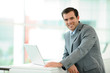© goodluz - Businessman using laptop computer in entrance hall