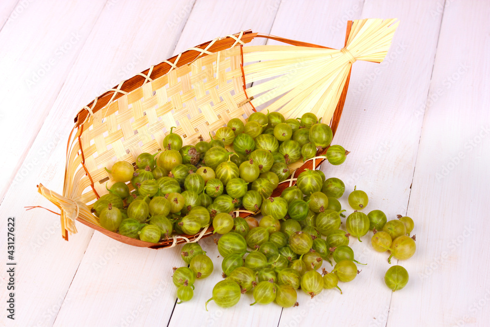 Green gooseberry in basket on wooden background