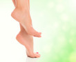female feet on blurred green background