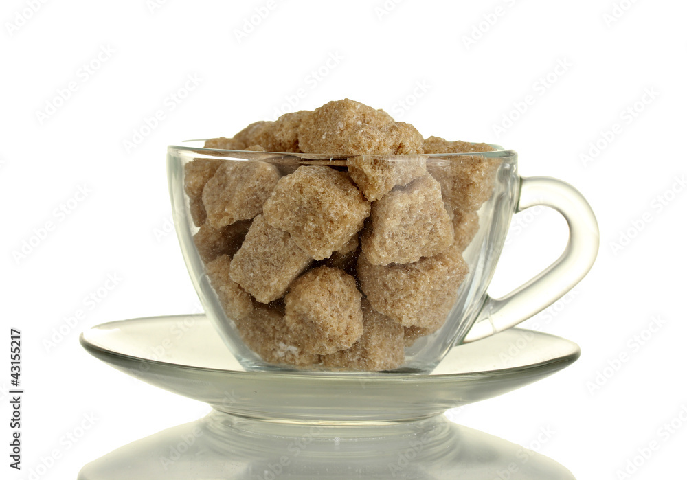 Lump brown cane sugar cubes in glass cup isolated on white