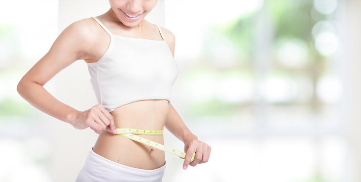 Woman smile measuring shape of waist