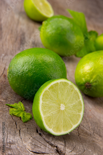 Fotoboard na płycie Świeże limonki na drewnianym stole