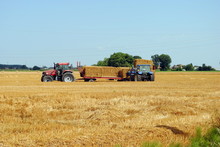 Tractors Load Bales Of Hay In Farmlands