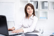 © GVS - Portrait of beautiful young smiling business woman working on a